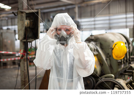 Chemical inspector female worker wearing protective mask and hazmat suit examining chemistry in industrial. Analysing harmful substances to human body and environment. 119737355