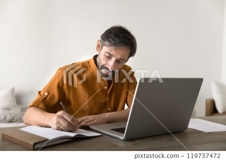 Focused Latin entrepreneur man in casual working at laptop 119737472