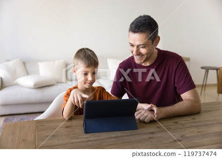 Positive dad teaching little son to use service on tablet 119737474