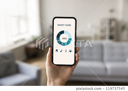 Woman hand hold cell with smart home app on screen Woman hand hold cell with smart home app on screen 119737545