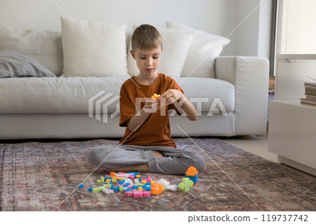 Cute little boy playing construction game at home Cute little boy playing construction game at home 119737742