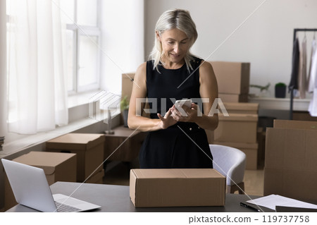 Elderly lady postal worker contact addressee by phone about shipping Elderly lady postal worker contact addressee by phone about shipping 119737758