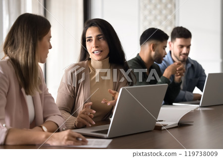 Attractive young Hispanic mentor woman training intern at laptop 119738009