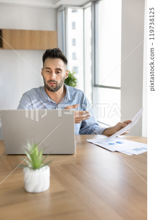Serious busy Latin startup manager man discussing marketing reports Serious busy Latin startup manager man discussing marketing reports 119738125