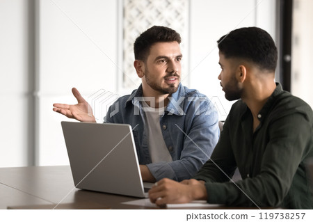 Confident young Middle Eastern startup leader man talking to partner Confident young Middle Eastern startup leader man talking to partner 119738257