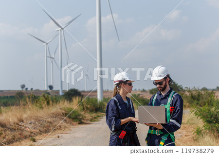 Team engineer wearing safety uniform holding laptop discussed plan about renewable energy at station energy power wind. technology protect environment reduce global warming problems. Team engineer wearing safety uniform holding laptop discussed plan about renewable energy at station energy power wind. technology protect environment reduce global warming problems. 119738279