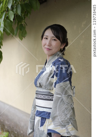 A young woman in a yukata standing against a wall A young woman in a yukata standing against a wall 119738485