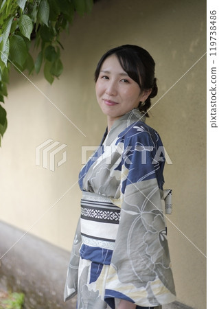 A young woman in a yukata standing against a wall A young woman in a yukata standing against a wall 119738486