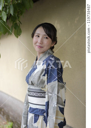 穿著浴衣的年輕女子靠牆站立 119738487