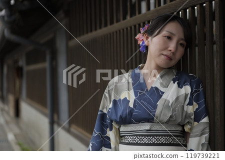 A young woman in a yukata standing at a lattice door A young woman in a yukata standing at a lattice door 119739221