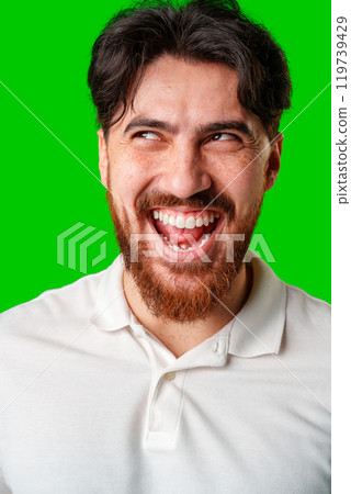 A man with a beard smiles confidently against a bright green background A man with a beard smiles confidently against a bright green background 119739429