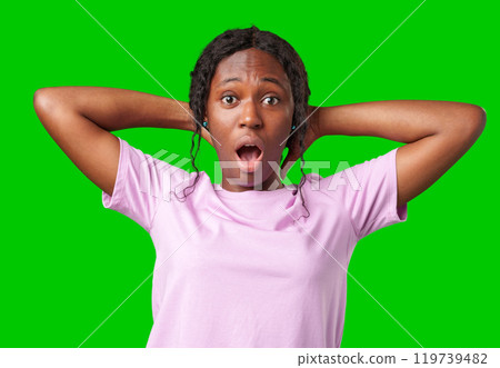 Woman expressing surprise and excitement on a bright green background Woman expressing surprise and excitement on a bright green background 119739482