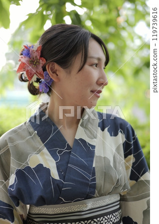 A young woman in a yukata standing in green leaves A young woman in a yukata standing in green leaves 119739616