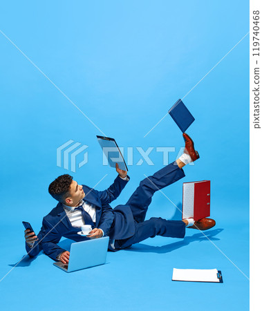 Creative collage. Businessman with multiple hands lying on floor, juggling cup, laptop, and phone. Modern workflow, dynamic business environments. Creative collage. Businessman with multiple hands lying on floor, juggling cup, laptop, and phone. Modern workflow, dynamic business environments. 119740468
