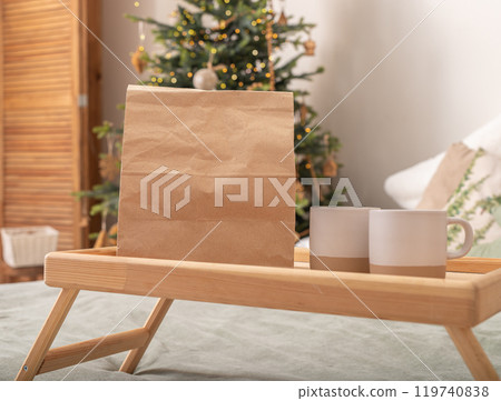 Paper bag and cups on wooden bed tray on Christmas holiday morning. Food delivery mockup Paper bag and cups on wooden bed tray on Christmas holiday morning. Food delivery mockup 119740838