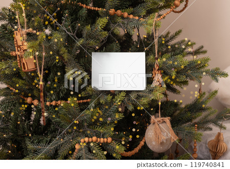 Gift certificate mockup, postcard mock up on Christmas tree Gift certificate mockup, postcard mock up on Christmas tree 119740841