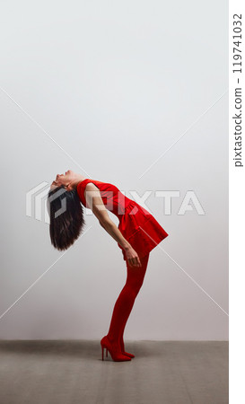 Woman in red arching her back, portraying freedom and emotional liberation. 119741032