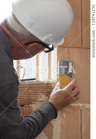 Craftsman measuring with horizontal rotary laser level. Construction or renovation site 119741230