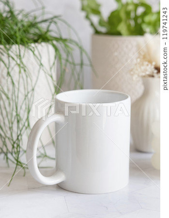 White coffee mug on white marble near potted green plants Close up, copy space, mock up White coffee mug on white marble near potted green plants Close up, copy space, mock up 119741243