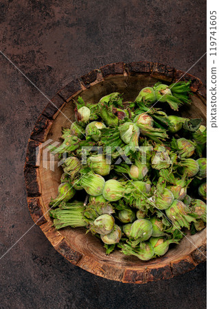 Fresh, green hazelnuts, close-up, in a wooden bowl, unpeeled, top view, no people, 119741605