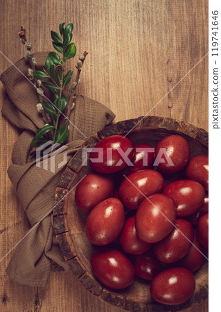 painted eggs in a wooden bowl, red, painted madder dye, powder from the roots of endro, with onion husks, top view, Easter, Georgia, 119741646