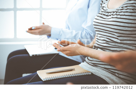 Business people clapping at meeting or conference, close-up of hands. Group of unknown businessmen and women in modern white office. Success teamwork, corporate coaching and applause concept Business people clapping at meeting or conference, close-up of hands. Group of unknown businessmen and women in modern white office. Success teamwork, corporate coaching and applause concept 119742012
