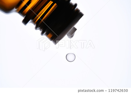 A drop of antihistamine or essential oil drips from a bottle. Close-up. 119742630