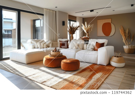 Stylish interior design with a white sofa adorned by orange cushions and sophisticated decor 119744362