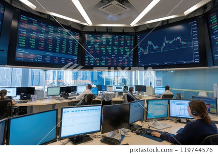 Stockbrokers working in a modern trading room with big screens showing data 119744576