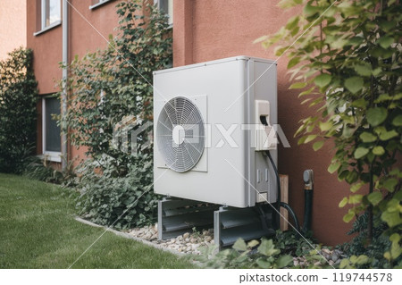 Heat pump installed on building wall, providing sustainable heating and cooling 119744578