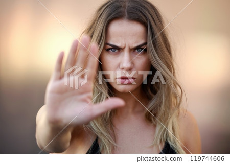 Portrait of a serious young woman gesturing stop with her hand 119744606
