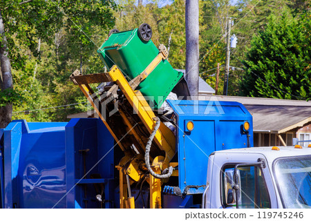 An employee of municipal cleaning service loads mixed domestic waste onto garbage truck for removal An employee of municipal cleaning service loads mixed domestic waste onto garbage truck for removal 119745246