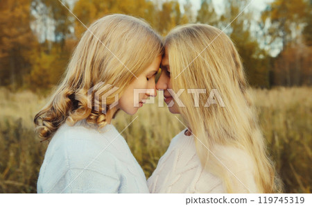 Happy two women, smiling mature mother and adult daughter hugging in autumn park Happy two women, smiling mature mother and adult daughter hugging in autumn park 119745319