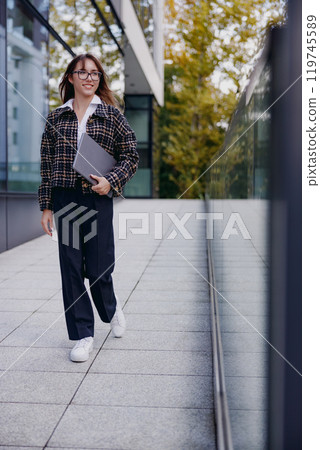 A Professional Woman Walking Confidently in a Modern Urban Environment with Purpose A Professional Woman Walking Confidently in a Modern Urban Environment with Purpose 119745589