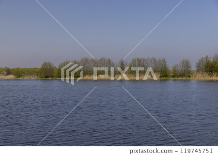 The blue water in the lake reflects the blue sky in spring 119745751