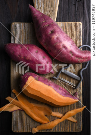 Pink organic raw sweet potatoes with vegetable peeler Pink organic raw sweet potatoes with vegetable peeler 119745957