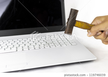 Image of a man smashing a laptop with a hammer (man, hands, no face) Image of a man smashing a laptop with a hammer (man, hands, no face) 119746039
