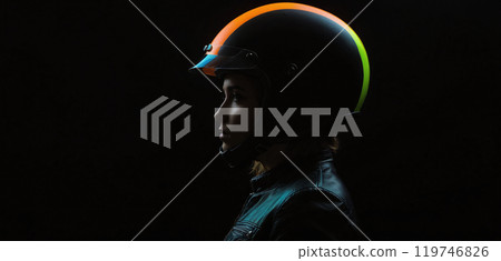 Conceptual depiction of a motorcyclist wearing a colored motorcycle helmet in a very dark and accentuated visual language - ai generated 119746826