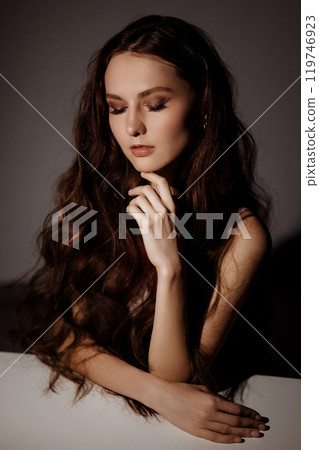 A woman with long brown hair and blue eyes is posing for a photo A woman with long brown hair and blue eyes is posing for a photo 119746923