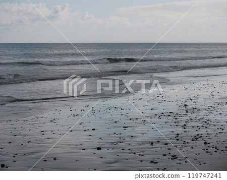 Seashore in sunlight with reflections on wet sand Seashore in sunlight with reflections on wet sand 119747241
