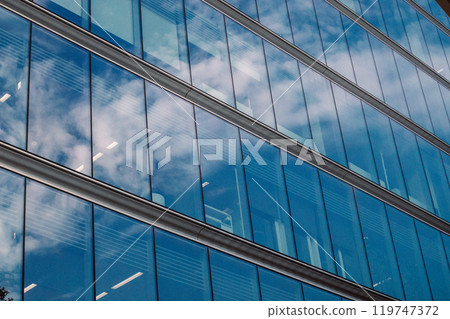 Modern office building glass facade, sky reflection in the windows of skyscraper 119747372