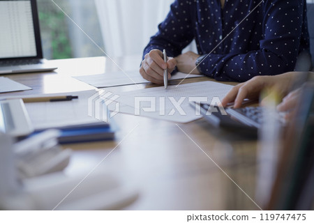 Accountants are analyzing paper reports and using calculators. Audit and taxes concept Accountants are analyzing paper reports and using calculators. Audit and taxes concept 119747475