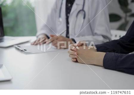 Doctor and a patient in clinic. The female physician is filling up medication history record form, close up of woman hands. Medicine concept 119747631