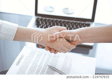 Business people shaking hands above contract papers just signed on the grey table, close up. Lawyers or entrepreneurs at meeting. Teamwork, partnership, success concept Business people shaking hands above contract papers just signed on the grey table, close up. Lawyers or entrepreneurs at meeting. Teamwork, partnership, success concept 119747635