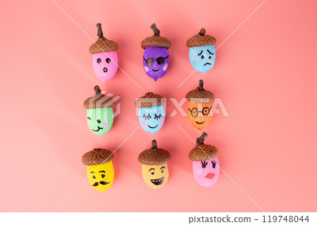 nine acorns painted in various colors with different facial expressions drawn on them, 119748044