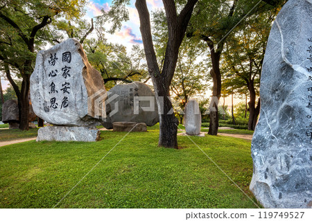 Sunset over park with engraved stones bearing Korean inscriptions commemorating the independence movement, near Namsan park Baekbeom Square. 119749527