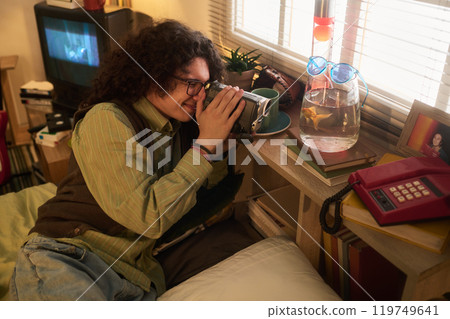 Person Drinking from Mug Sitting on Bed Near Window 119749641