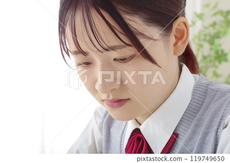 A high school girl thinking with a serious expression A high school girl thinking with a serious expression 119749650