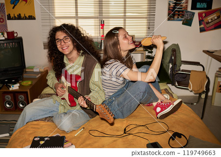 Playing Music and Singing in Cozy Bedroom Setting Playing Music and Singing in Cozy Bedroom Setting 119749663