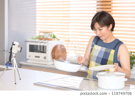 A woman recording a cooking video in the kitchen 119749706